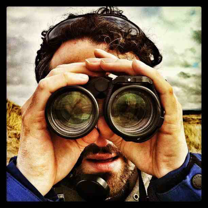 Duncan looking through a pair of binoculars