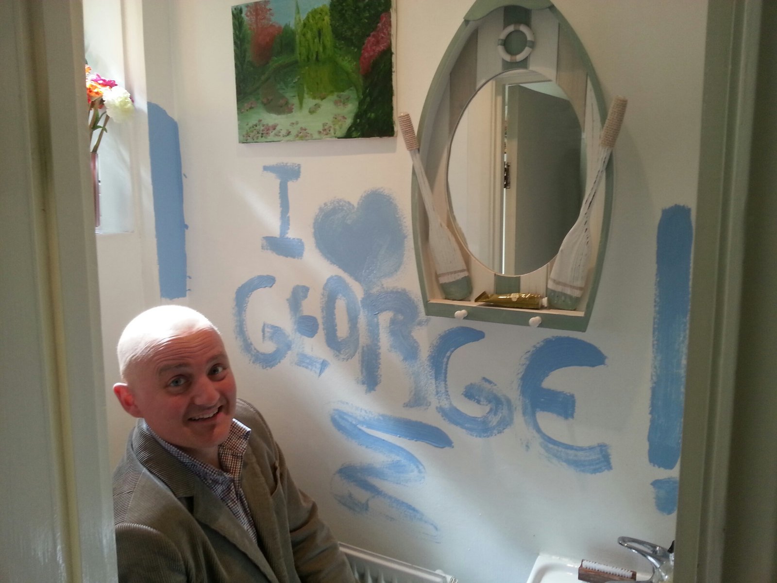 George in the bathroom, with 'I love George' painted on the wall