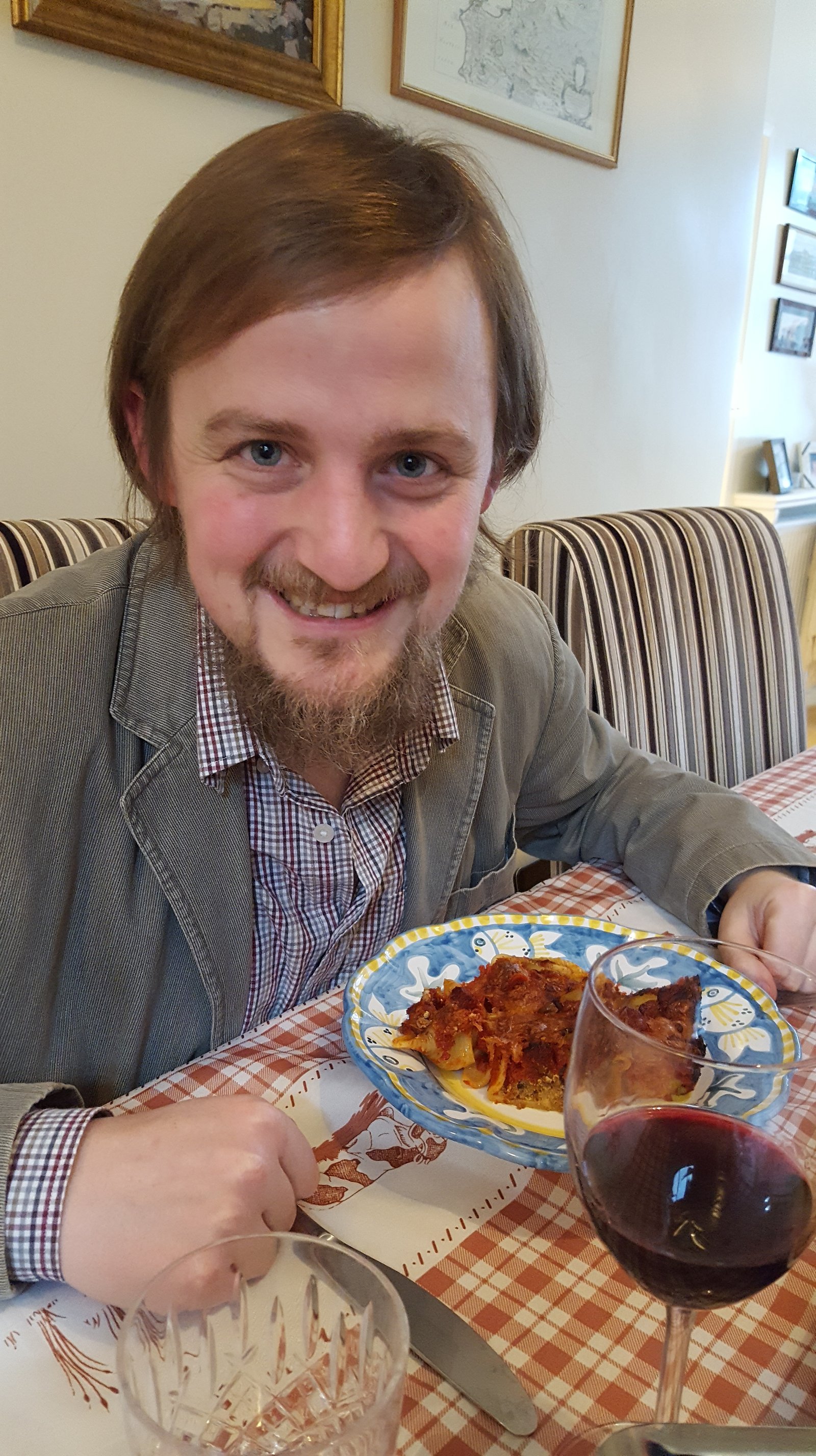 George (with long hair) eating a pasta dish
