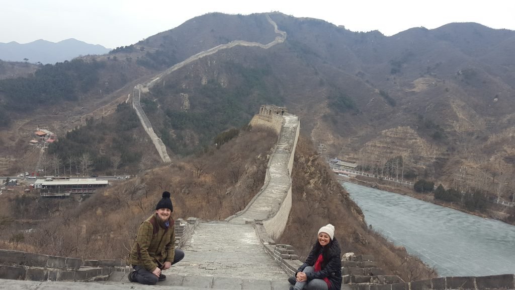 George and Mariacristina on the Great Wall of China, with it snaking away over the mountain in the background